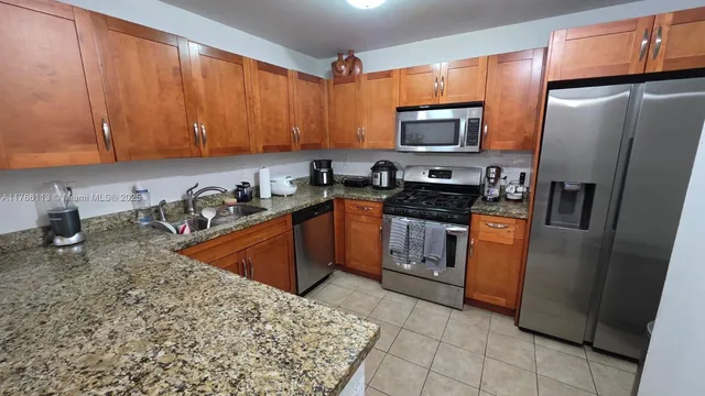 a kitchen with stainless steel appliances granite countertop a sink stove and cabinets
