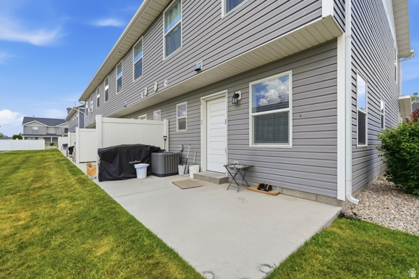 391 South 440th Street West Preston, ID 83263 - Photo 21 of 28 Concrete patio area with a white privacy fence and a manicured lawn