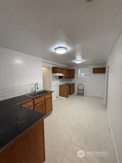 1414 East Fir Street Seattle, WA 98122 - Photo 15 of 30 a kitchen with kitchen island a sink stove and wooden cabinets