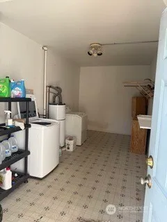 a room with a washing machine and a wooden floor