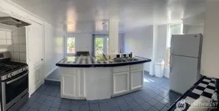 a kitchen with stainless steel appliances a sink a stove a refrigerator and cabinets