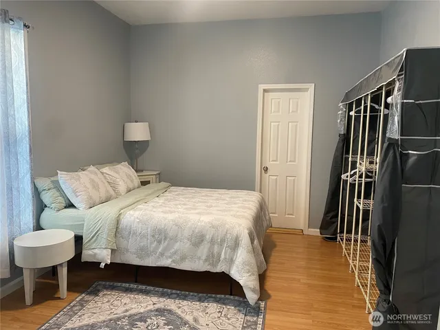 a bedroom with a bed and wooden floor