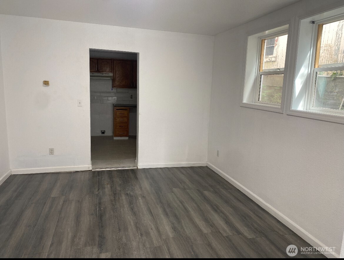 1414 East Fir Street Seattle, WA 98122 - Photo 4 of 30 an empty room with wooden floor and windows