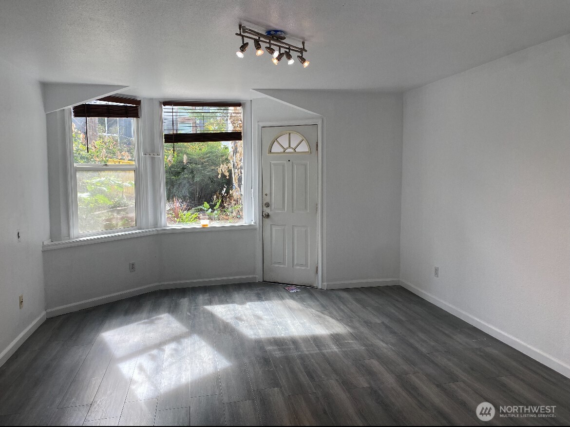 1414 East Fir Street Seattle, WA 98122 - Photo 5 of 30 an empty room with wooden floor and windows