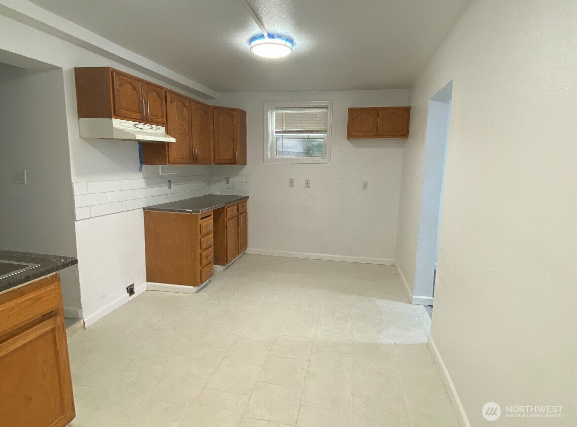1414 East Fir Street Seattle, WA 98122 - Photo 9 of 30 a kitchen with granite countertop a sink and a stove top oven