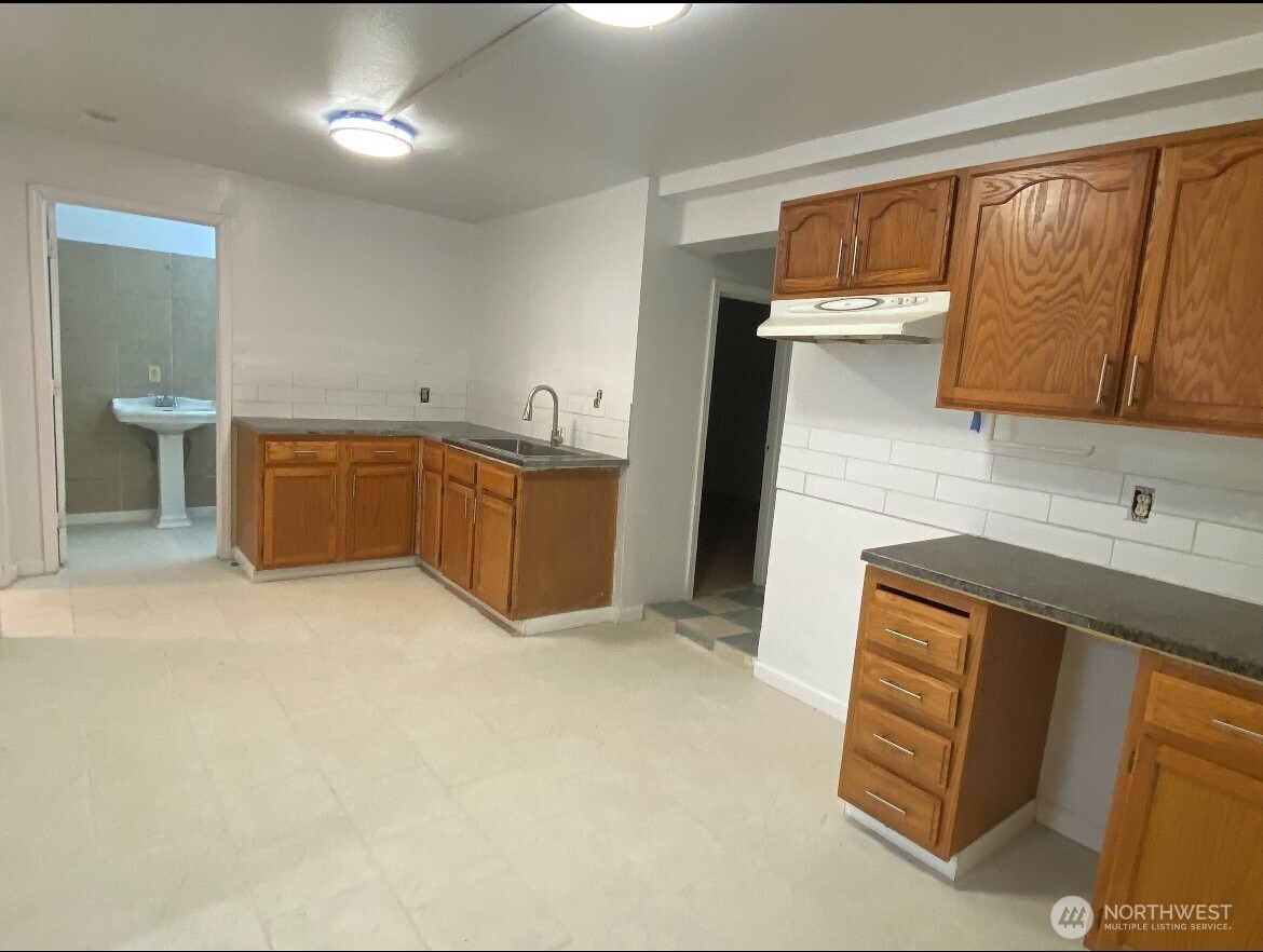 1414 East Fir Street Seattle, WA 98122 - Photo 10 of 30 a kitchen with cabinets a sink and wooden floor