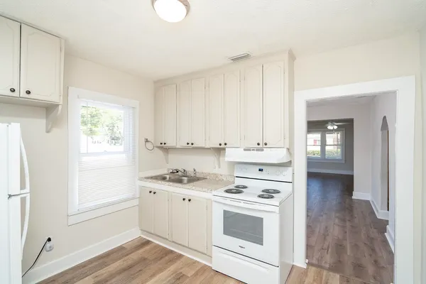 a kitchen with white cabinets and white appliances