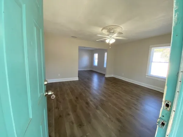 a view of a room with wooden floor and a ceiling fan
