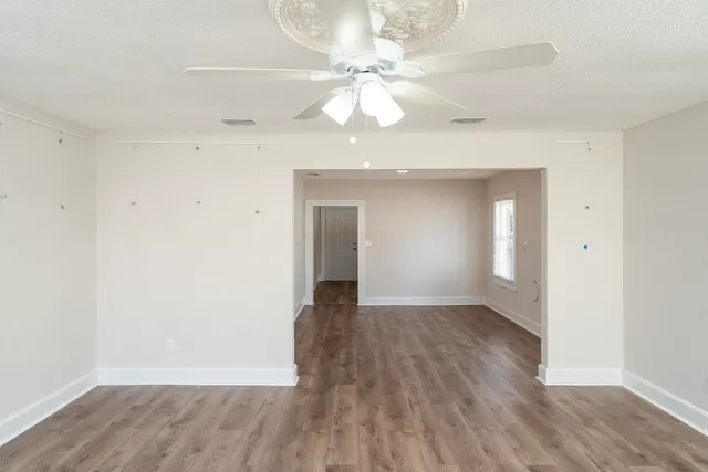 wooden floor in an empty room with a window