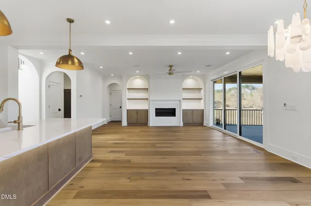 a view of an empty room with wooden floor and closet