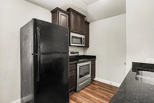 a metallic refrigerator freezer sitting in a kitchen
