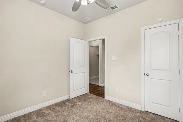 an empty room with a ceiling fan and a window