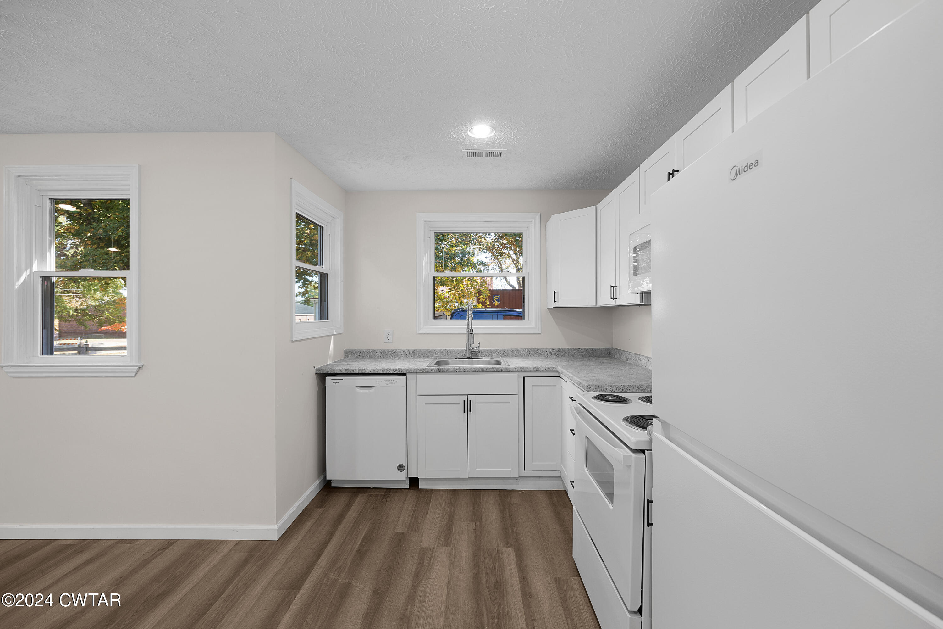 309 West Knox Street Rutherford, TN 38369 - Photo 7 of 16 a kitchen with granite countertop white cabinets and white appliances
