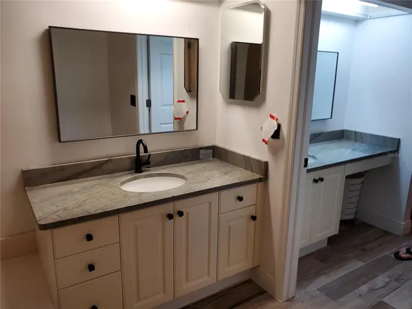 a bathroom with a granite countertop sink and a mirror