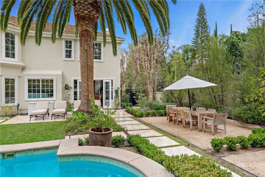 1 Meryton Irvine, CA 92603 - Photo 38 of 40 a view of a patio with couches table and chairs under an umbrella with a garden