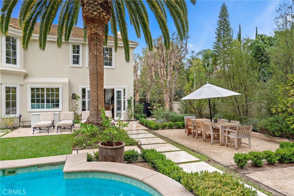 1 Meryton Irvine, CA 92603 - Photo 6 of 40 a view of a patio with couches table and chairs under an umbrella with a garden