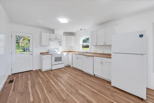 a kitchen with white cabinets and white appliances