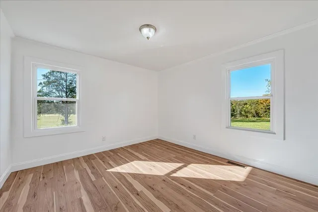 a view of empty room with wooden floor