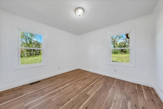 wooden floor in an empty room with a window