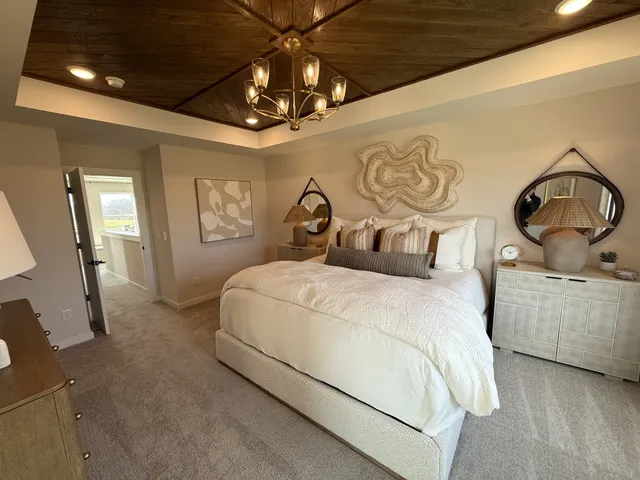a bedroom with a large bed and a chandelier