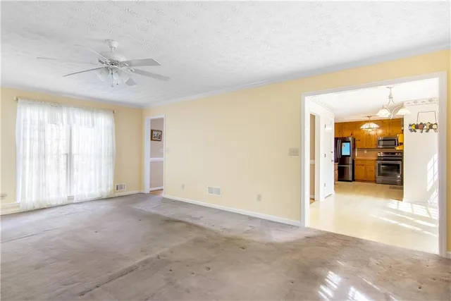 an empty room with fan and windows