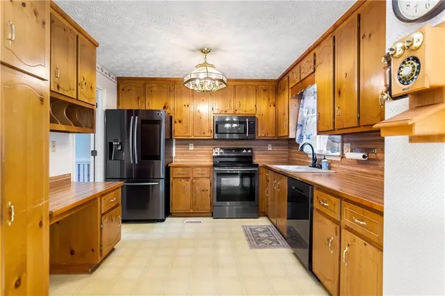 a kitchen with stainless steel appliances granite countertop a refrigerator a stove top oven a sink and dishwasher