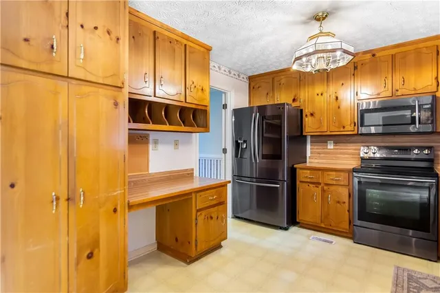 a kitchen with stainless steel appliances granite countertop a refrigerator and a stove