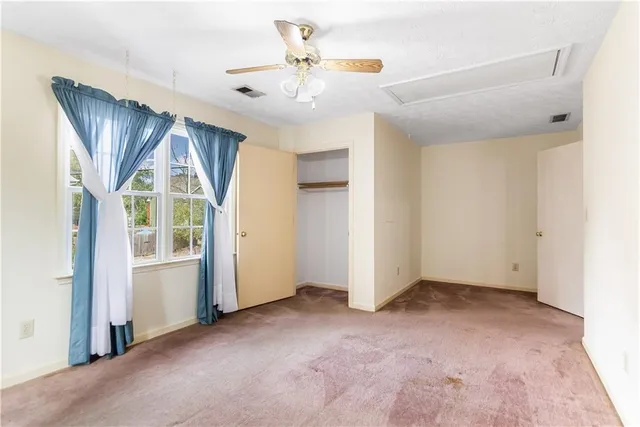 an empty room with windows and closet