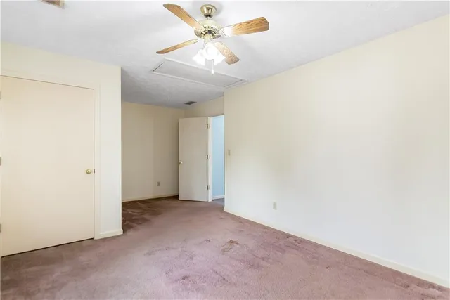 an empty room with a ceiling fan and a window