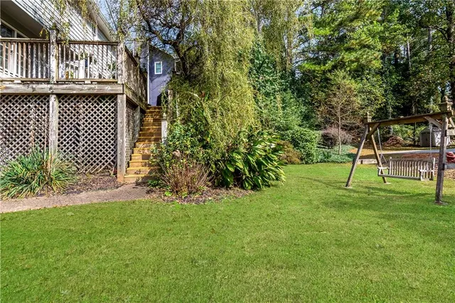 a view of a backyard with wooden fence and a bench