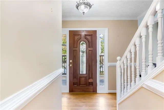 a view of a hallway with wooden floor and staircase