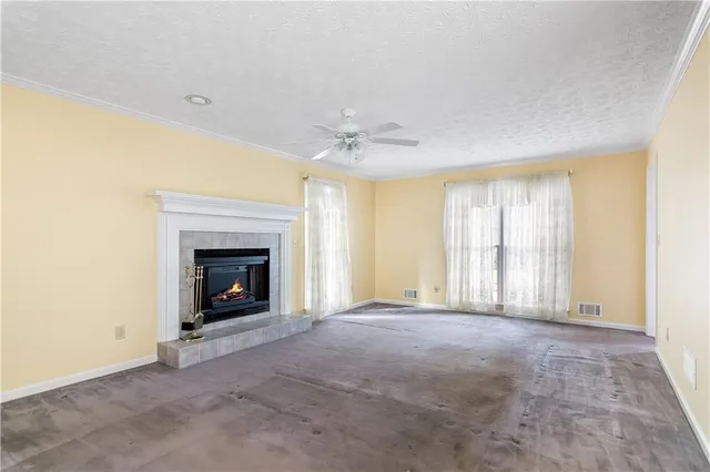 a view of an empty room with a window and a fireplace