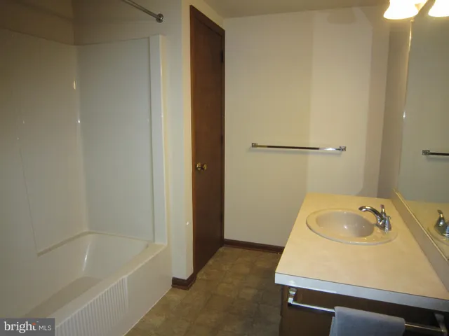 a bathroom with a tub sink and vanity