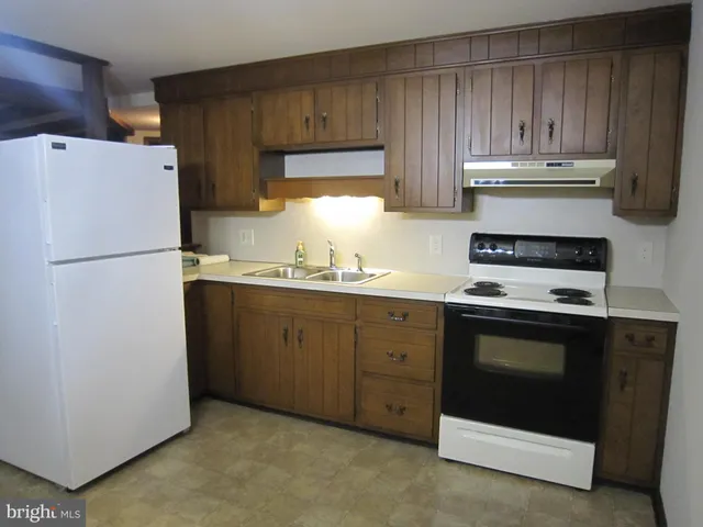 a kitchen with appliances a sink and a refrigerator