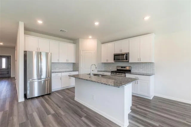 a kitchen with wooden cabinets and stainless steel appliances