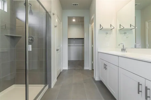a bathroom with a double vanity sink a mirror and a shower