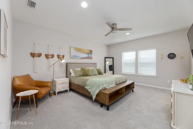 a spacious bedroom with a bed and a chair