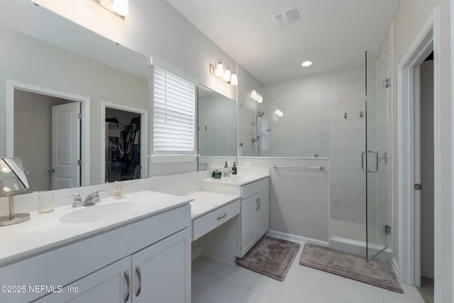 a bathroom with a double vanity sink mirror and shower
