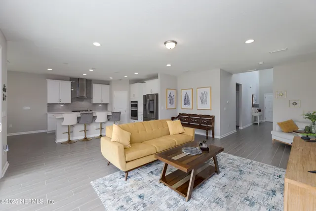 a living room with furniture and view of kitchen