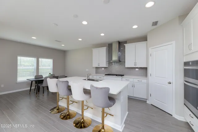 a kitchen with a dining table chairs appliances and cabinets