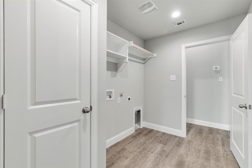 915 Timber Ridge Drive Justin, TX 76247 - Photo 14 of 39 Laundry area featuring wood-finish flooring, white baseboards, and light gray walls