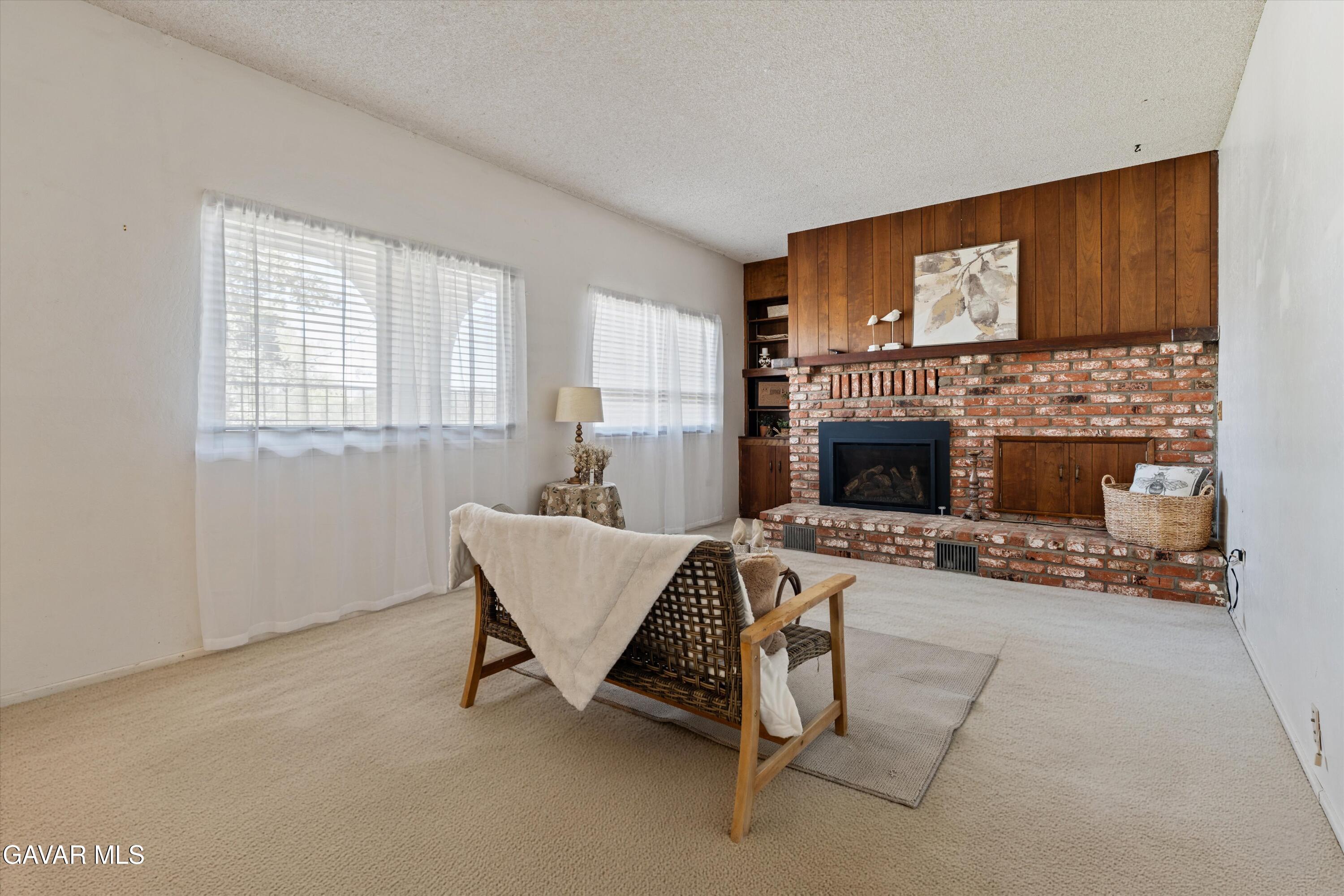 22217 Valley Vista Drive Tehachapi, CA 93561 - Photo 2 of 17 a living room with furniture a fireplace and a flat screen tv
