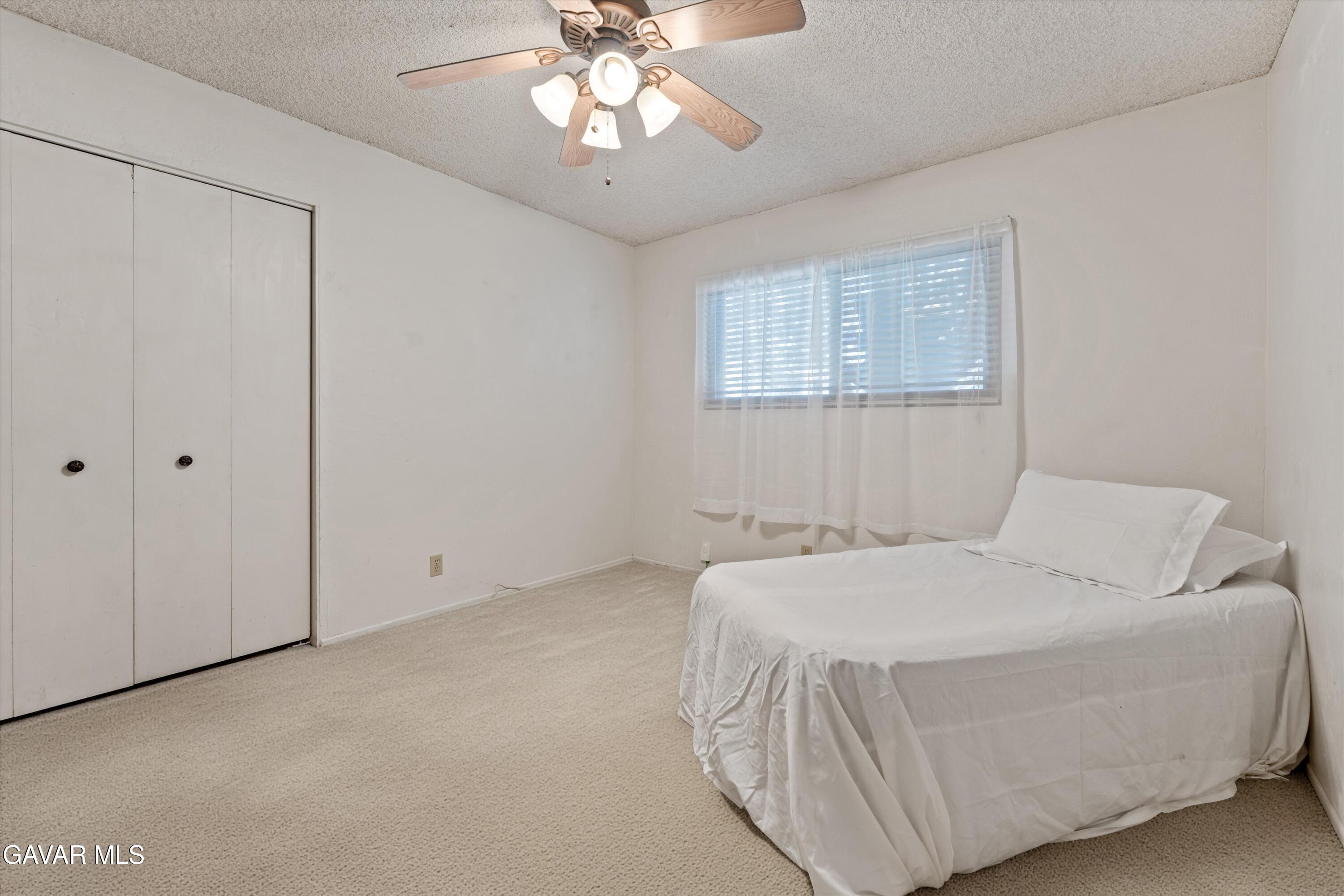 22217 Valley Vista Drive Tehachapi, CA 93561 - Photo 8 of 17 a bedroom with a bed and a chandelier