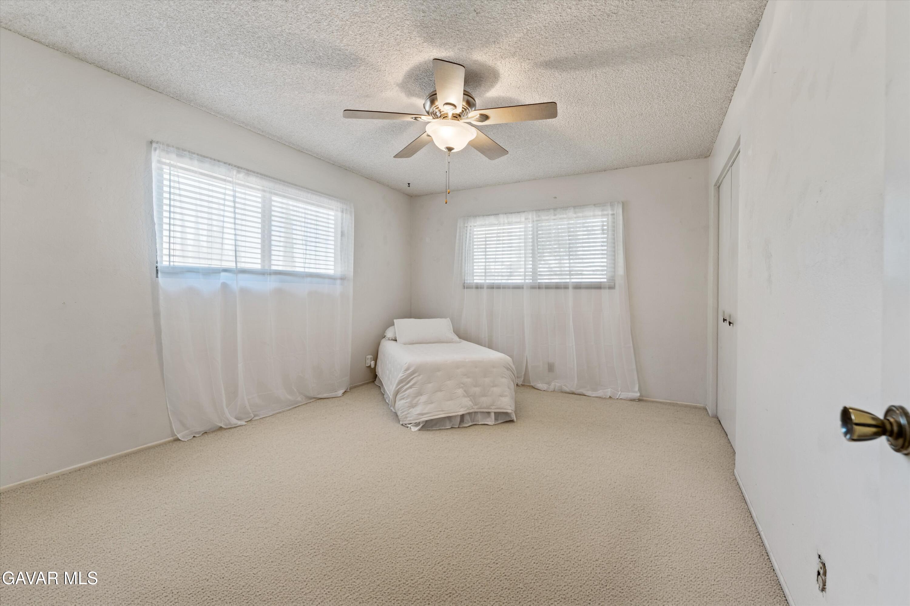 22217 Valley Vista Drive Tehachapi, CA 93561 - Photo 9 of 17 an empty room with windows and fan