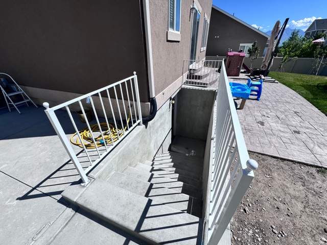 4729 Middleboro Road Herriman, UT 84096 - Photo 2 of 19 Exterior basement entry featuring concrete stairs and white metal railings