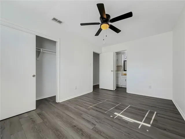 a view of empty room with wooden floor and window