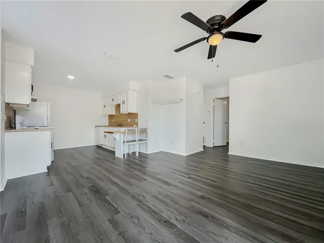 a kitchen with wooden floors and white walls