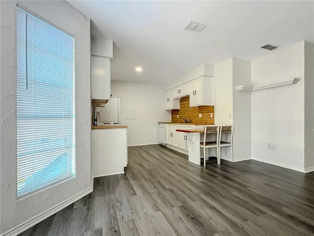 a kitchen with stainless steel appliances a refrigerator and wooden floor