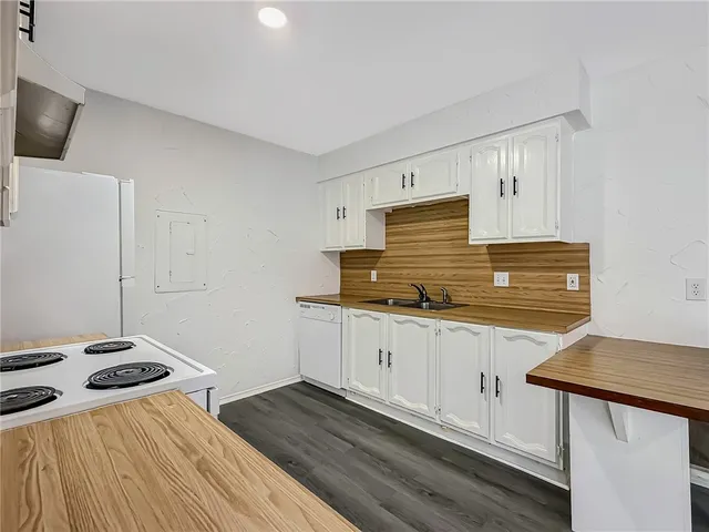 a kitchen with granite countertop a stove and a sink