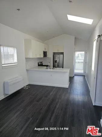 a view of a room with wooden floor and electronic appliances
